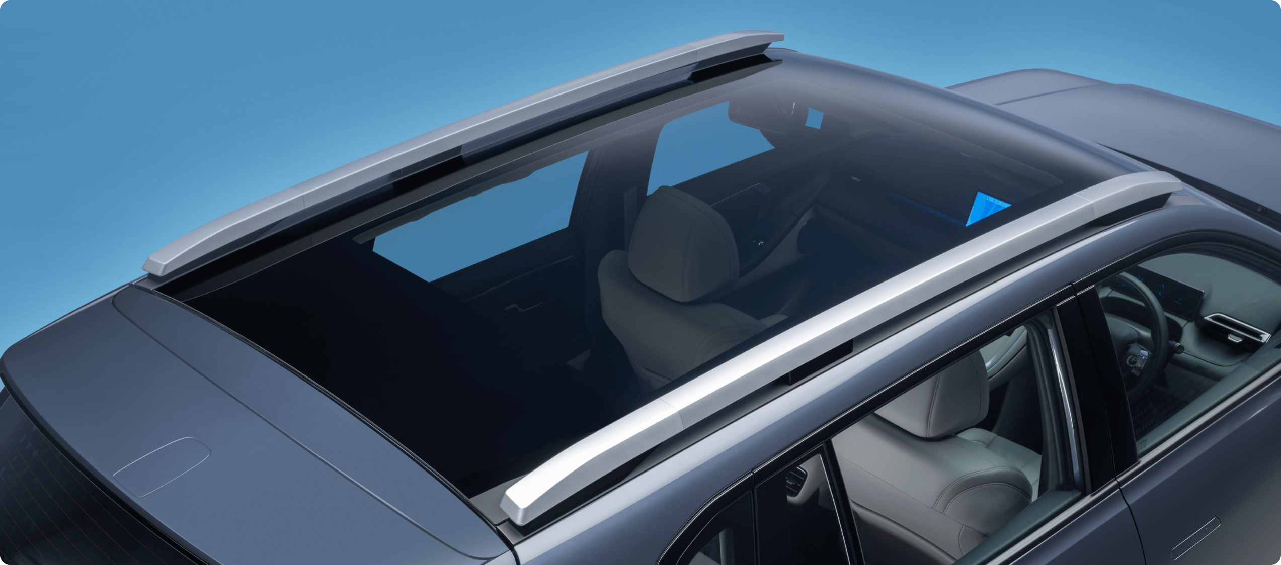 Car with a glass sunroof and silver roof rails, interior partially visible.
