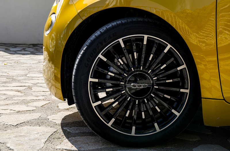 Close-up of a yellow car’s front wheel with Goodyear tyre and alloy rim.