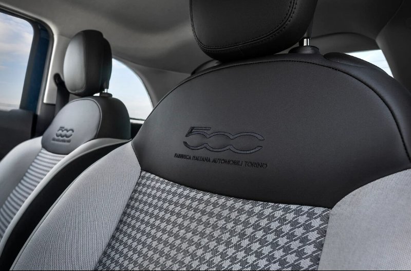 Front seats of a Fiat 500 with houndstooth pattern and embroidered logo.