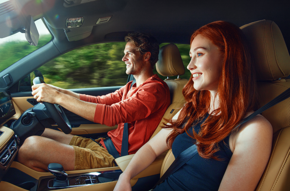 Man driving a car with a woman in the passenger seat.